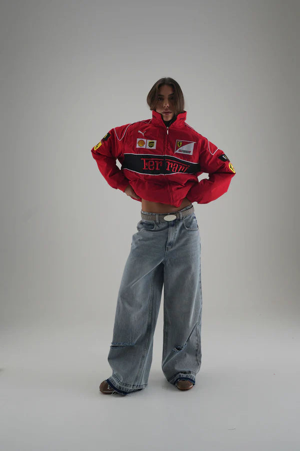 Person wearing a  red ferrari racing suit with various logos on a gray background