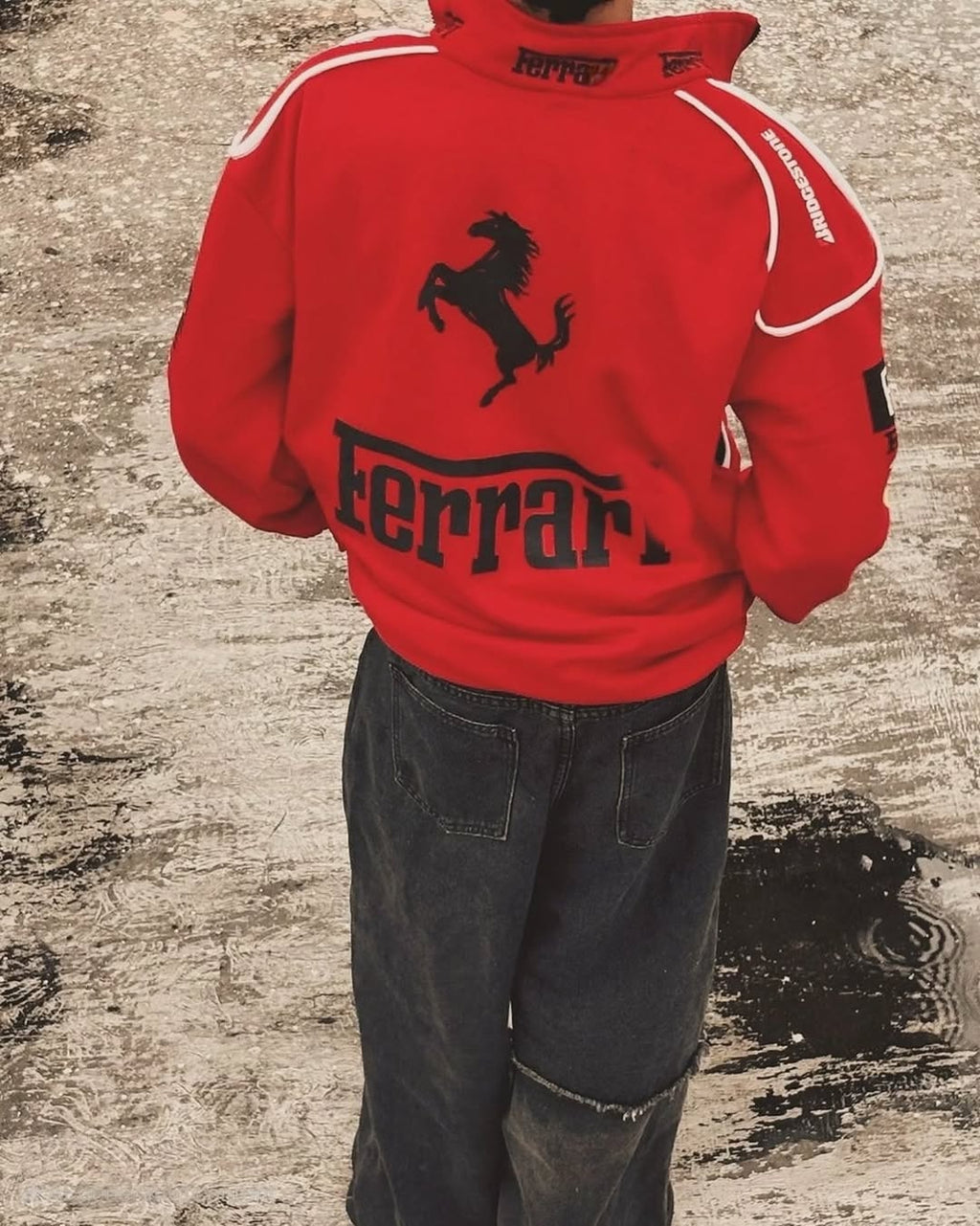 Red Ferrari jacket with horse logo on a textured surface