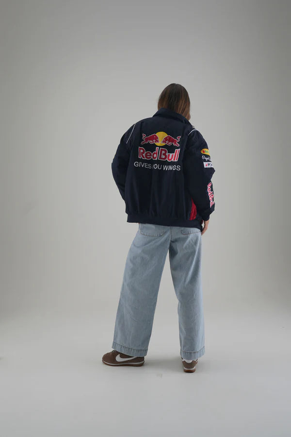 Person wearing a Red Bull jacket on a plain background