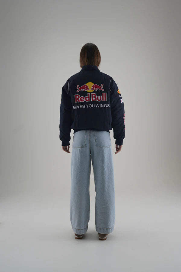 Person wearing a Red Bull jacket on a plain background