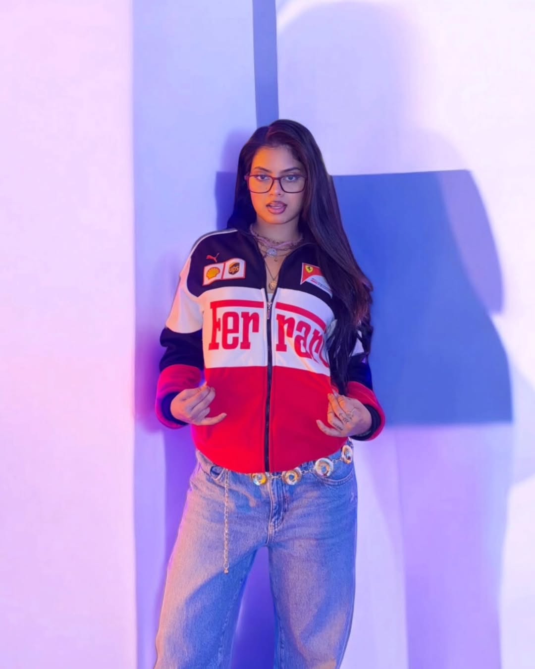 Person wearing a colorful jacket with brand logos against a light background