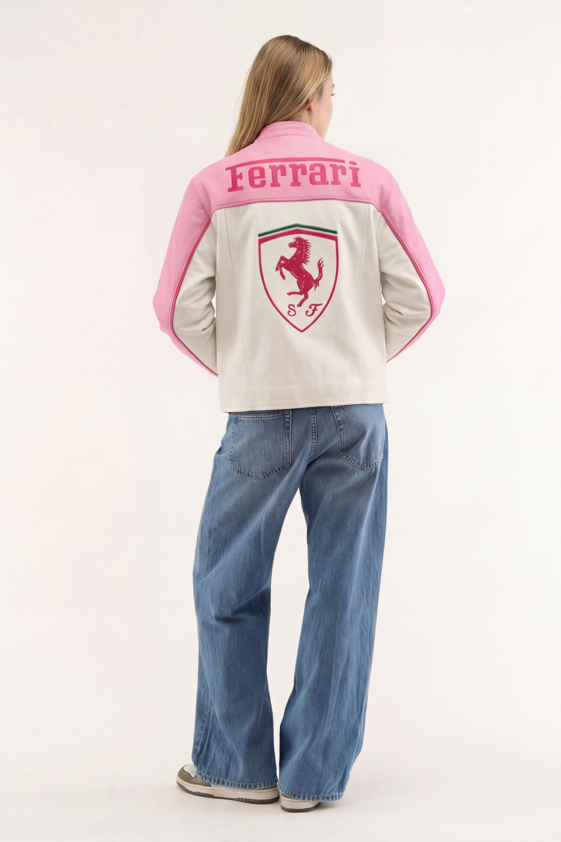 Back view of a woman wearing the Baby Pink Ferrari Leather Jacket by Streetbred, displaying the large embroidered prancing horse logo.
