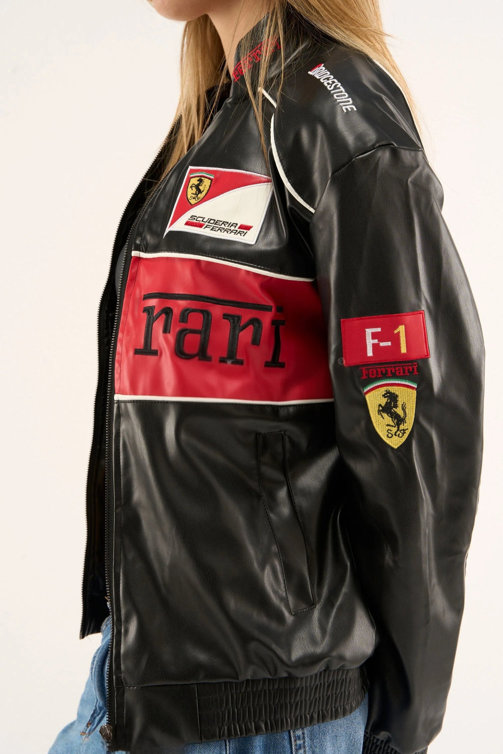 Macro close-up of the Black Ferrari F1 Leather Jacket by Streetbred, specifically highlighting the premium high-density embroidery and the rich, structured faux leather texture.