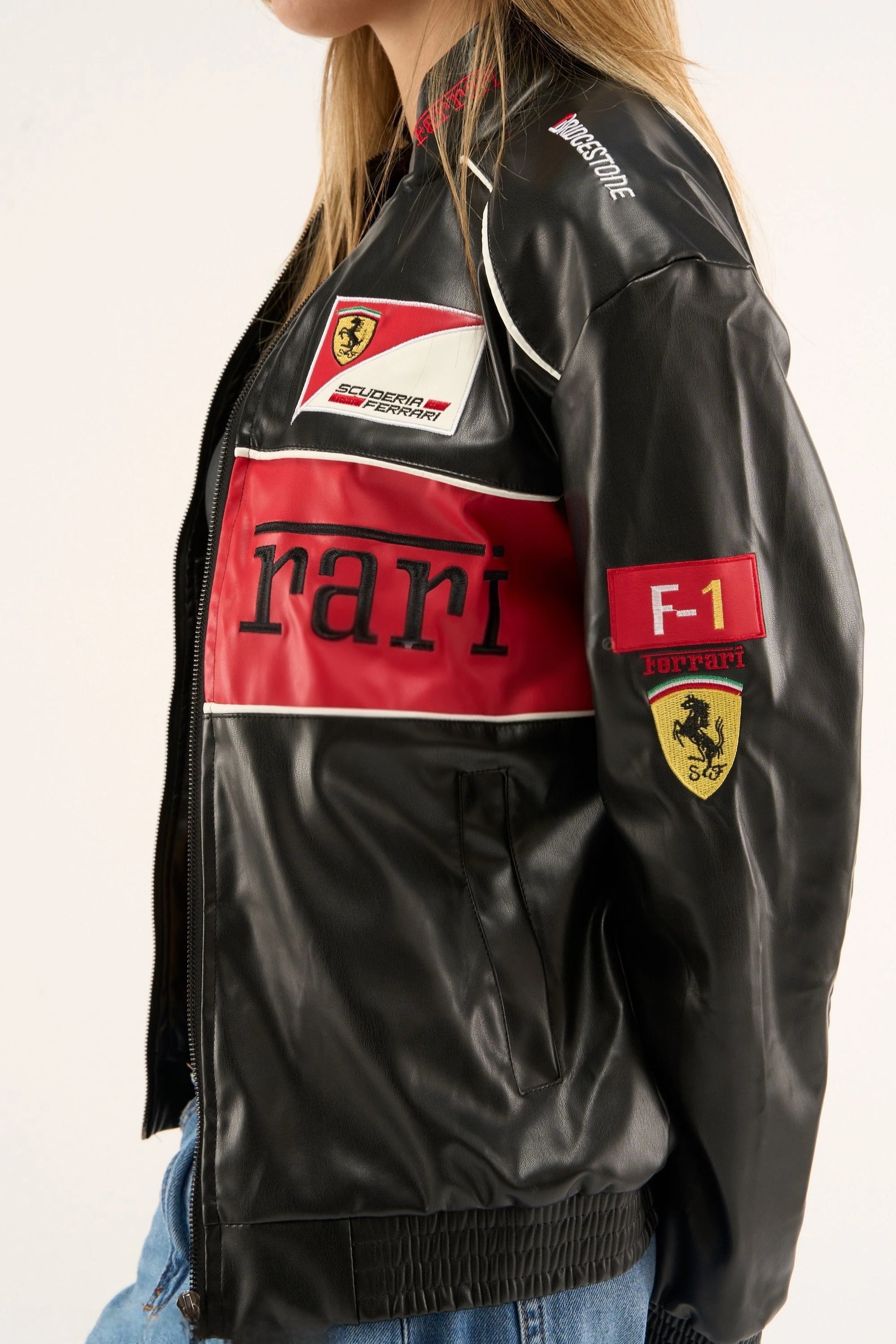 Macro close-up of the Black Ferrari F1 Leather Jacket by Streetbred, specifically highlighting the premium high-density embroidery and the rich, structured faux leather texture.