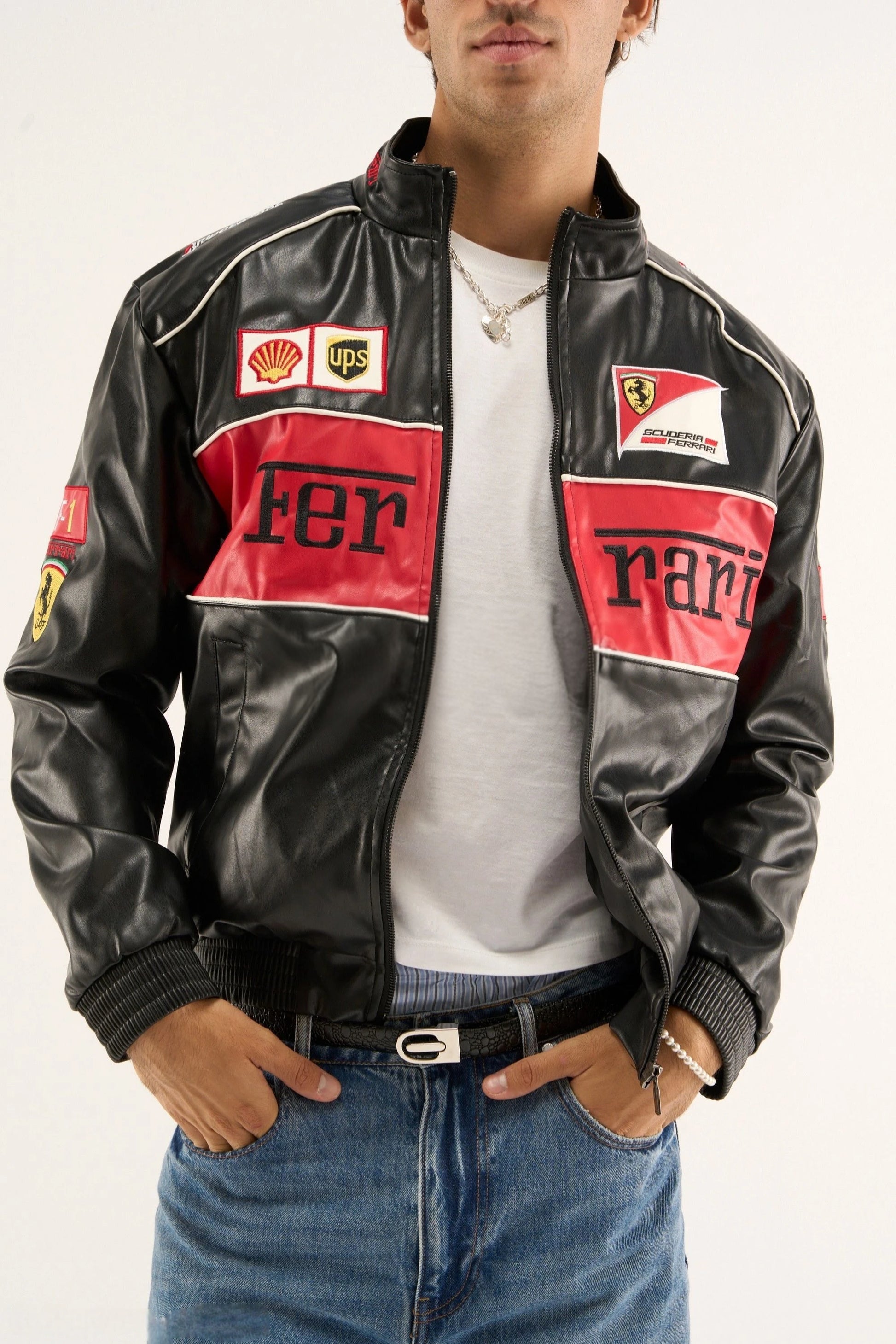 Front view of the unisex Black Ferrari F1 Leather Jacket by Streetbred on a male model, highlighting the elastic bottom hem and embroidered sponsor patches.