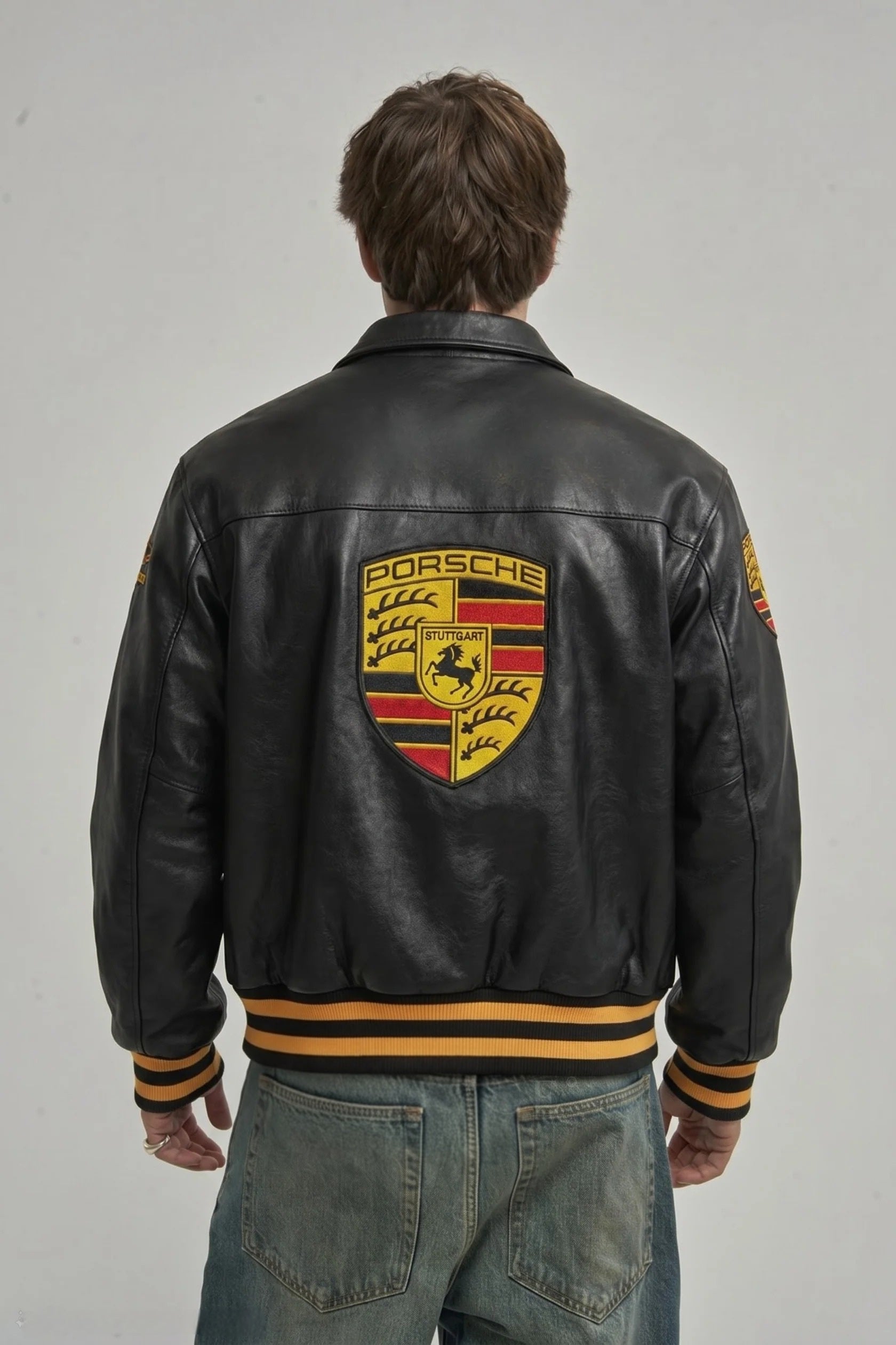 Back view of a man modeling the Black Porsche 993 Leather Jacket by Streetbred, displaying the large, premium embroidered Porsche logo.