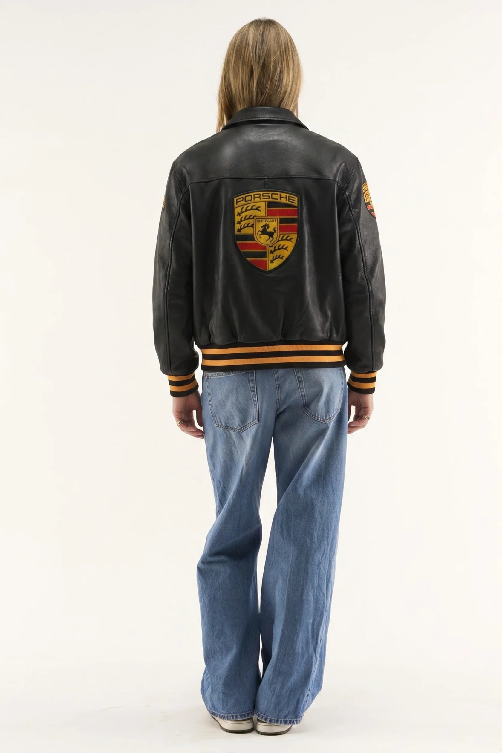 Womens back view of the stealth black Porsche racing jacket by Streetbred, featuring high-quality faux leather and vintage automotive embroidery.