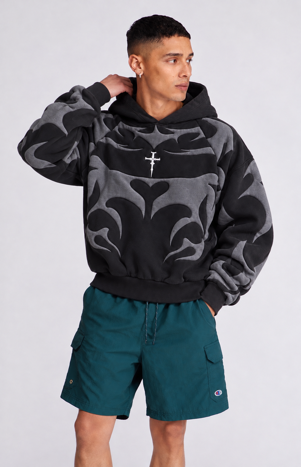 Lifestyle shot of a boy styling the heavyweight black fleece hoodie for winter, showing the relaxed baggy fit.
