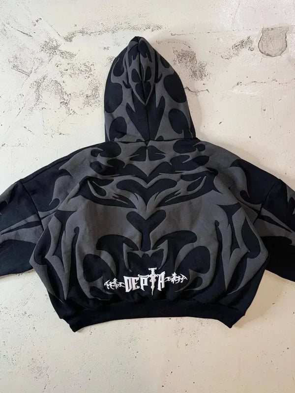 Black hoodie with abstract design and visible branding on a textured surface