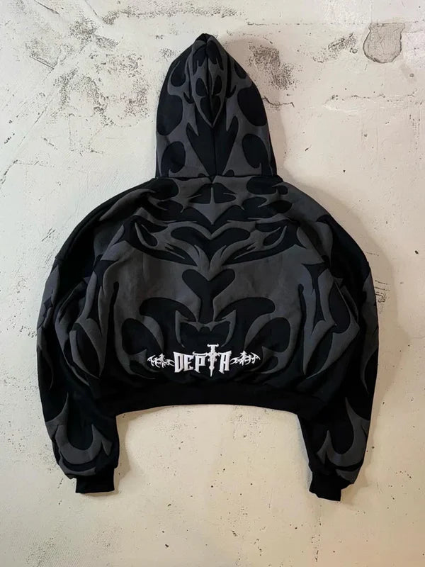 Black hoodie with tribal patterns on a textured white background