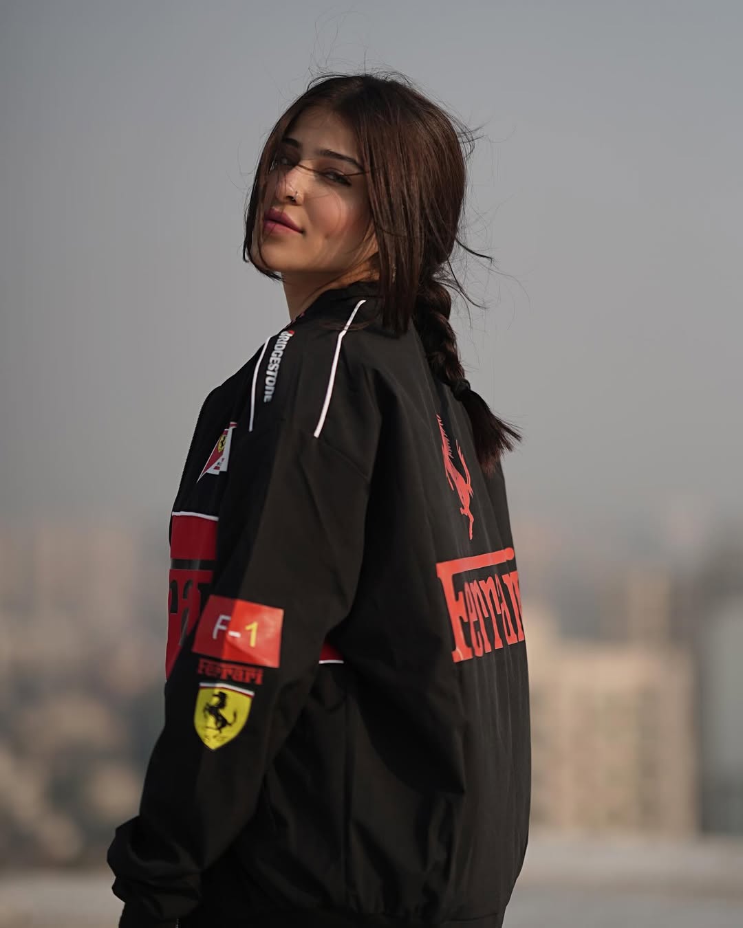 Oversized streetwear styling on a woman featuring the Streetbred Black Ferrari F1 Jacket and high-definition motorsport prints.