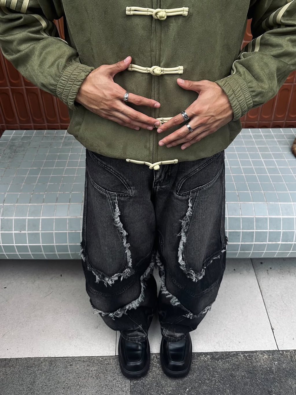 Full body style shot showing the male model layering the Olive Green CNY Suede Jacket exactly as intended. Paired with heavy streetwear cargo pants to push the aggressive, wide Gen-Z streetwear silhouette.
