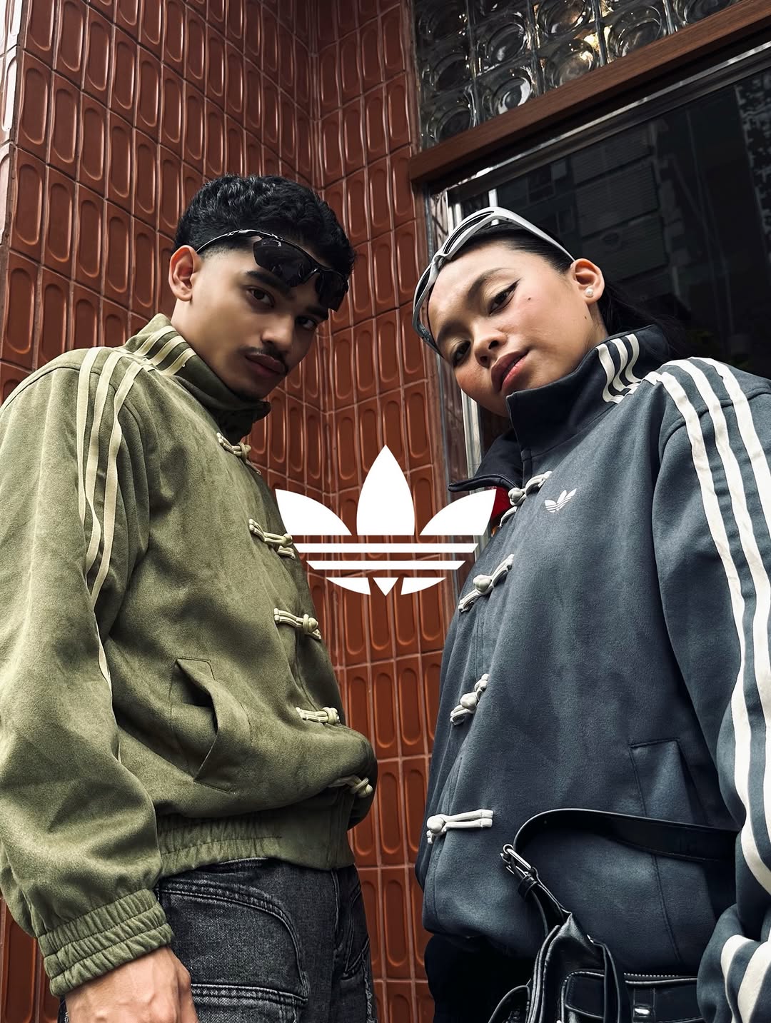 Close-up lifestyle shot of the matching vegan suede CNY jackets on two models. Highlights the premium 420 GSM velvet texture and the traditional Chinese toggle button-knots fastening the jackets.