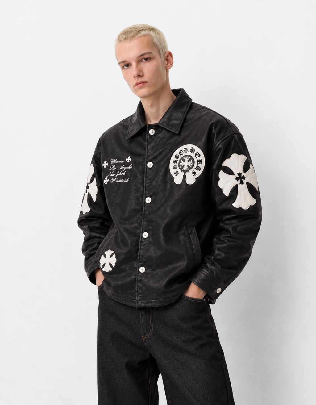 Front view of a boy styling the black leather cross patch jacket, showing the functional side welt pockets and silver snap buttons
