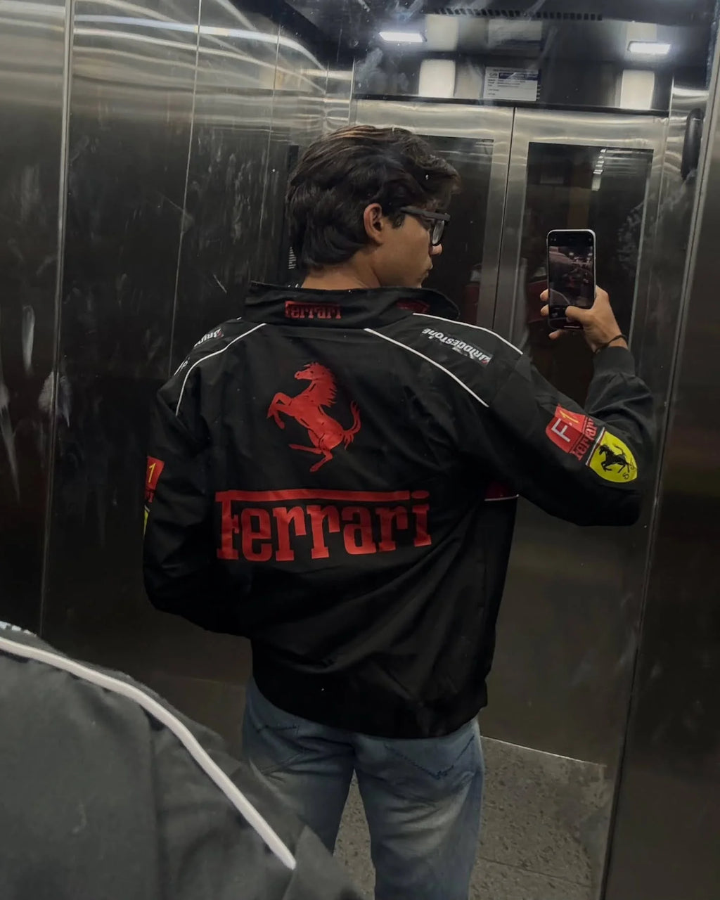 Male streetwear styling featuring the bold 3D prints of the Streetbred Black Ferrari F1 Jacket.