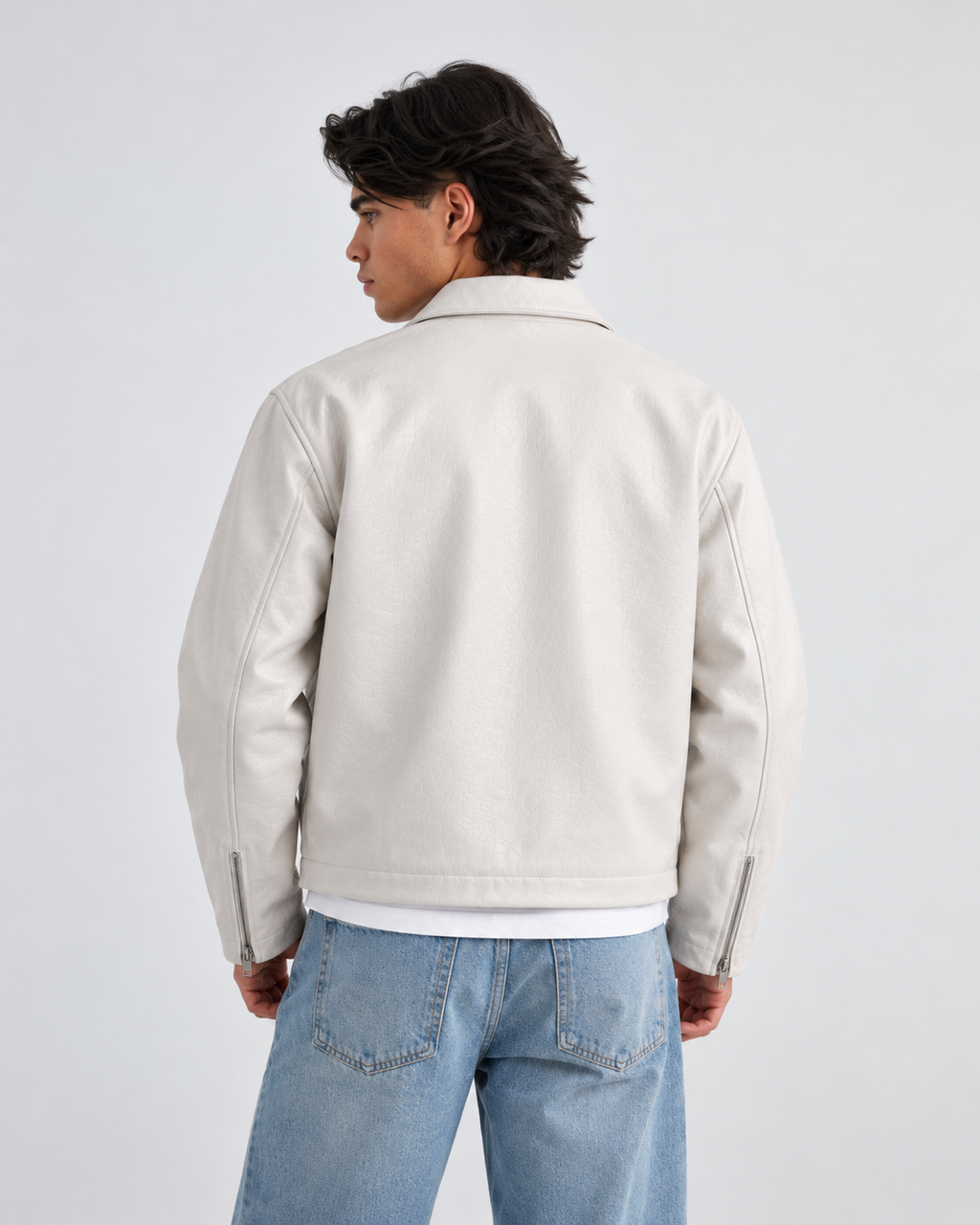 Front styling view of the male model demonstrating how the boxy white jacket contrasts perfectly when layered over dark winter clothing