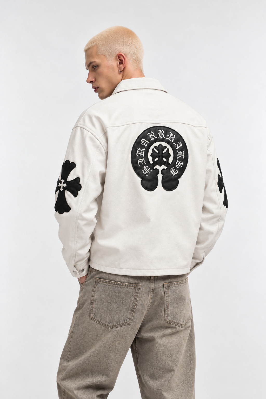 Back view of a male model in the off-white jacket, displaying the large black leather horseshoe crest and sleeve cross patches