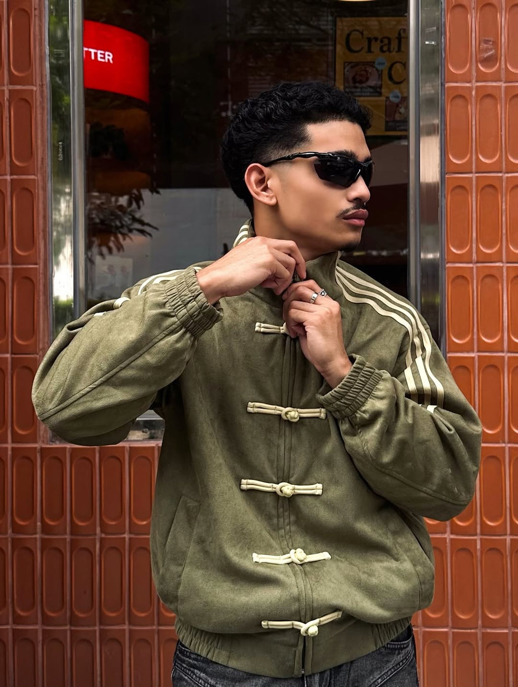 Direct front view of the male model wearing the Olive Green CNY Knot Jacket. The rich 420 GSM vegan suede provides a commanding, hyper-masculine Gorpcore aesthetic with authentic traditional toggle closures.