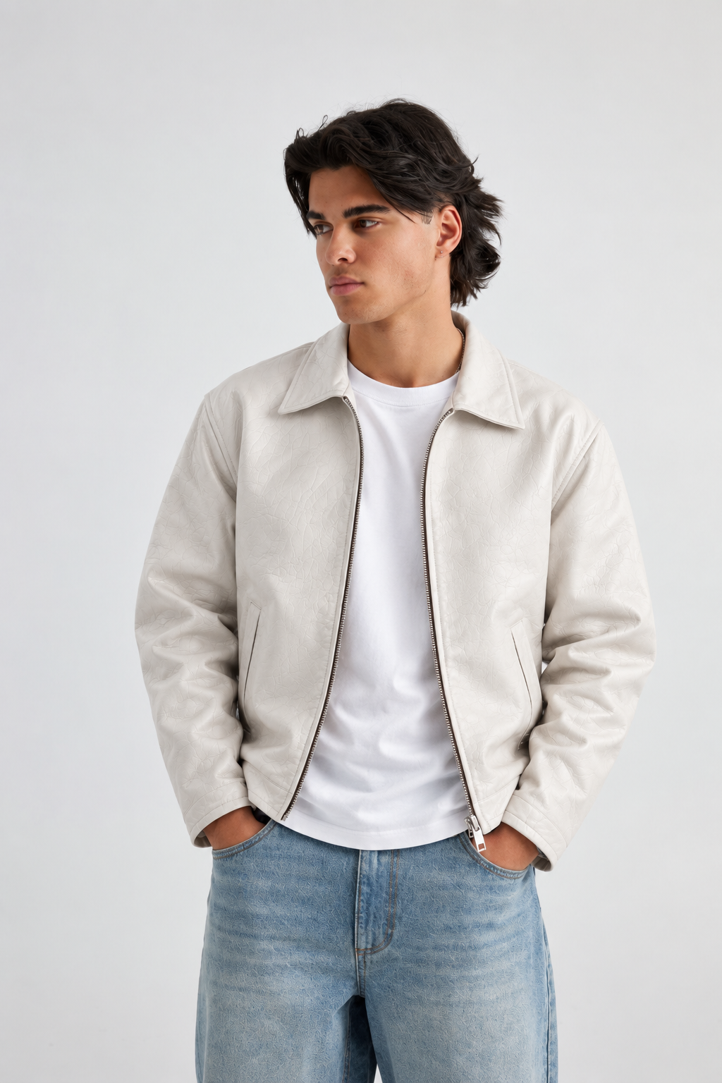 Male model wearing the Streetbred pristine white PU leather jacket, highlighting the high-waist cropped cut and dramatic drop shoulders