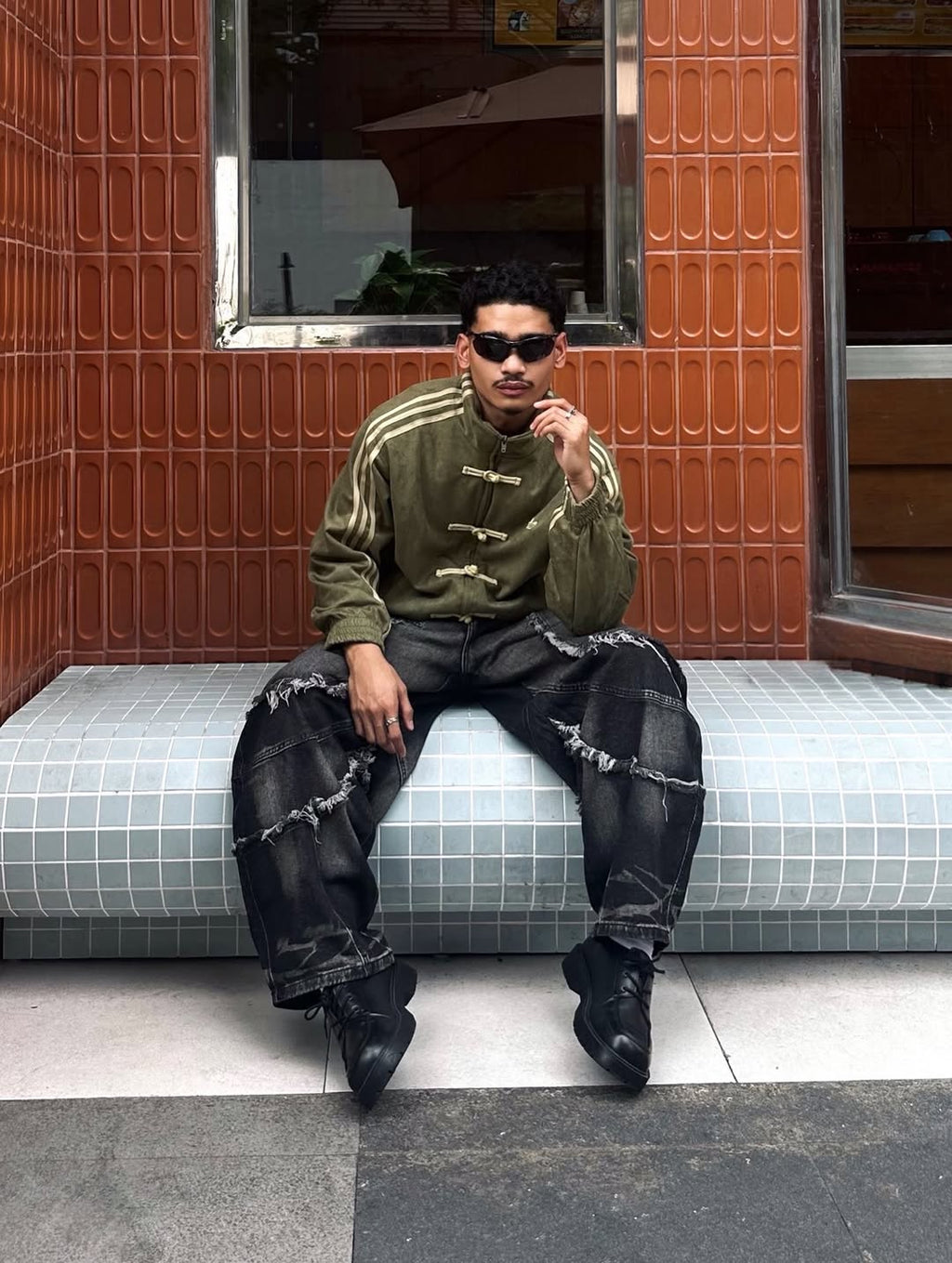 Macro texture shot of the Olive Green suede shell on the male model. Explicitly reveals the brushed velvet finish and the stark contrast of the traditional Chinese knot buttons against the premium synthetic matrix.