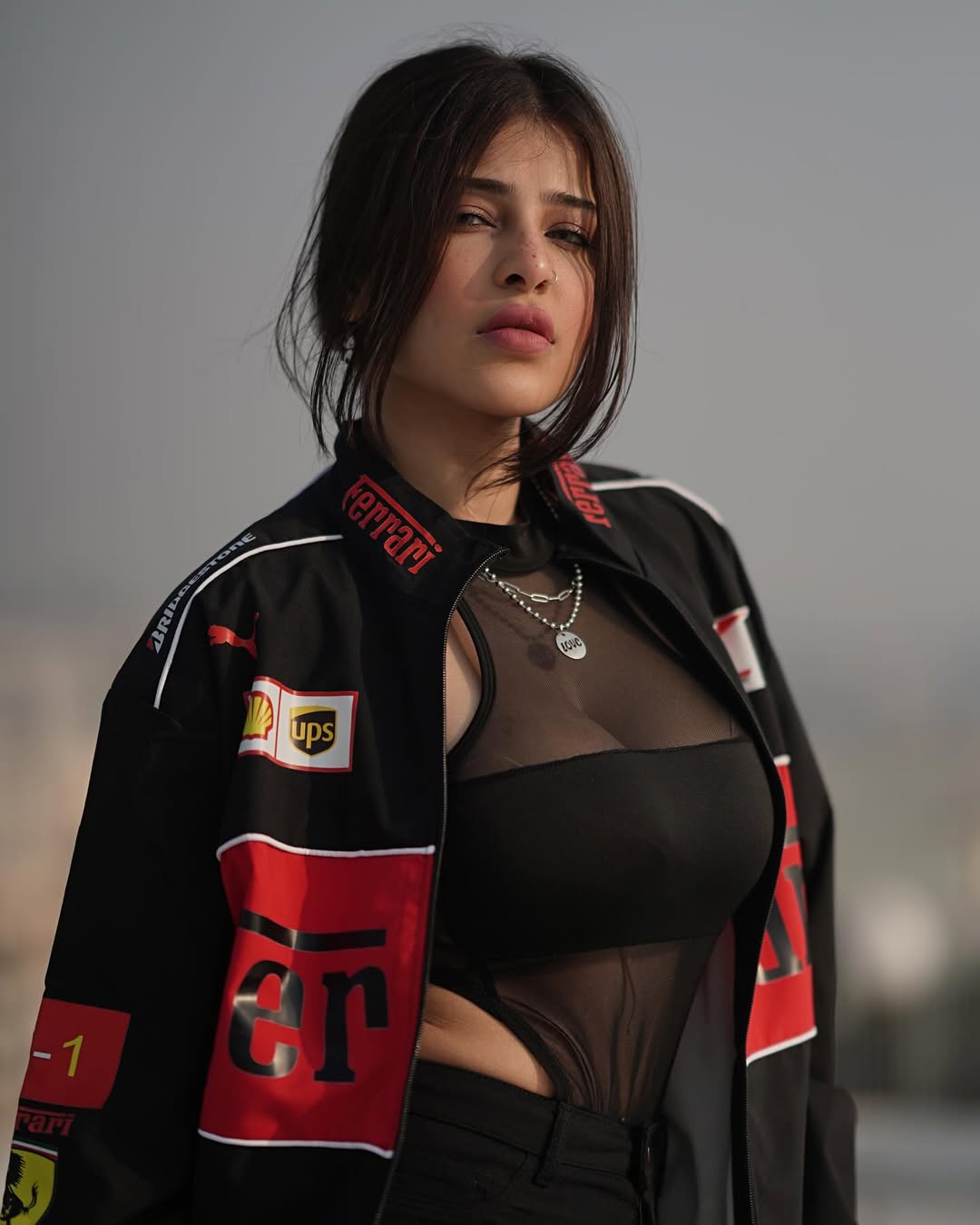 Female model showcasing the retro-modern racing aesthetic of the Streetbred Black Ferrari F1 Jacket.