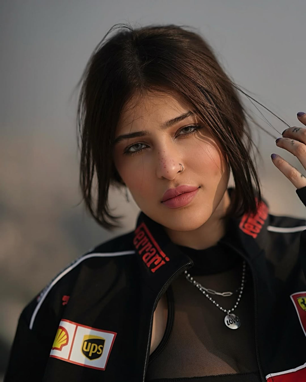 Lifestyle outdoor shot of a woman in the city styling the Streetbred Black Ferrari F1 Jacket.