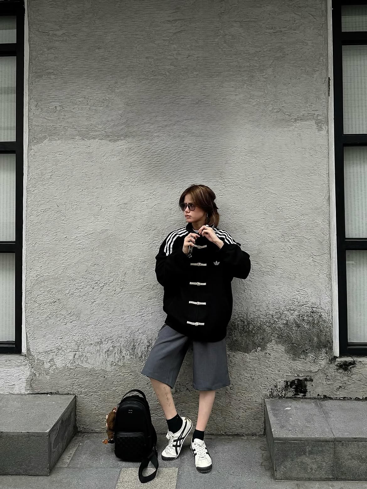 Woman wearing the Unisex Black CNY Adidas Knot Jacket by Streetbred, highlighting the Korean oversized streetwear drape and traditional frog buttons.
