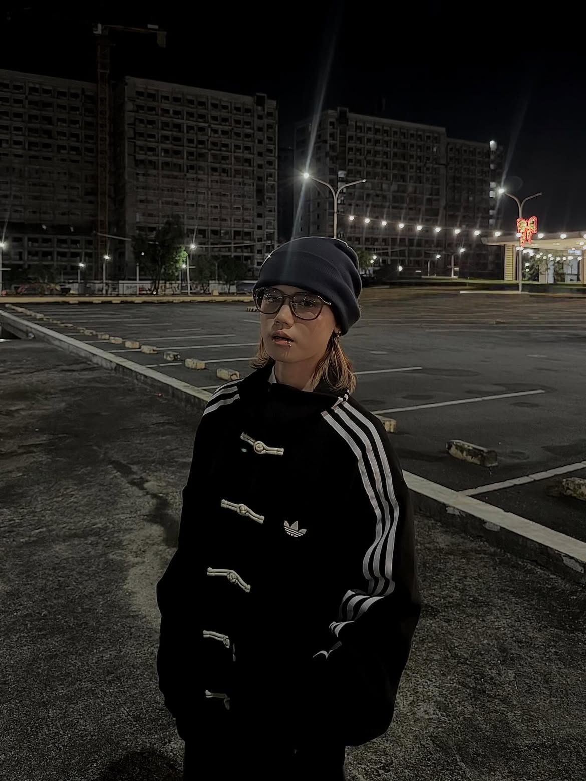 Female model styling the Black CNY Suede Jacket, showcasing the authentic Adidas thread embroidery and comfortable polyester inner lining.