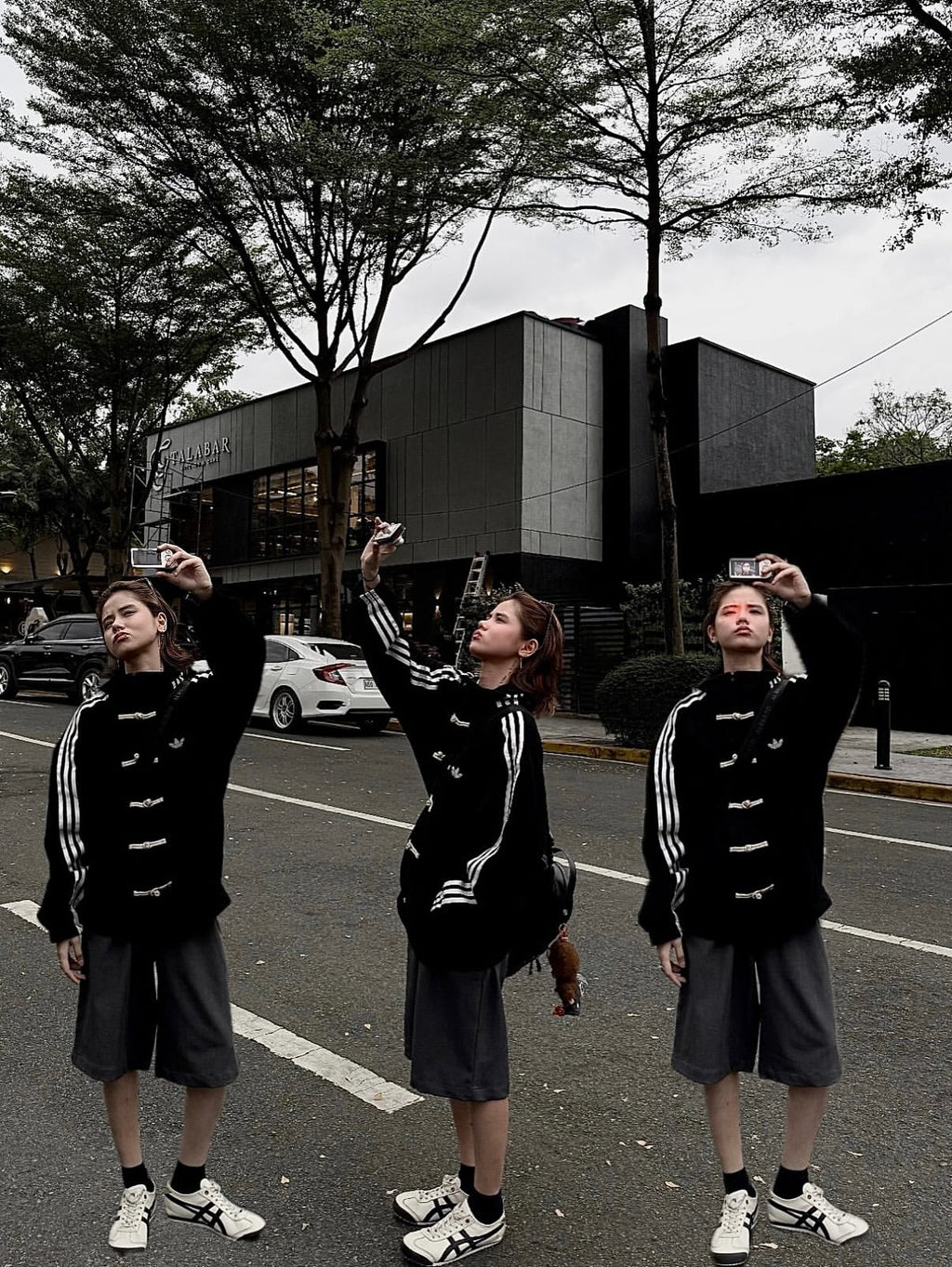 Streetwear look featuring a woman in the deep black Lunar New Year Adidas jacket, displaying the aesthetic sleeve stripes