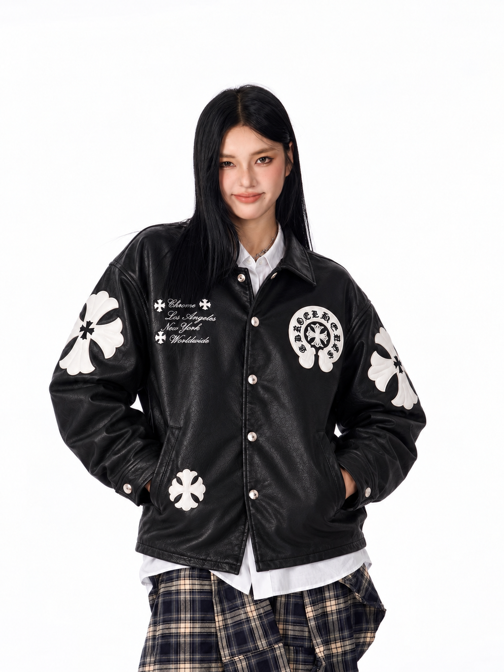 Streetwear front angle of a female model styling the black cross patch faux leather jacket with high-waisted baggy denim