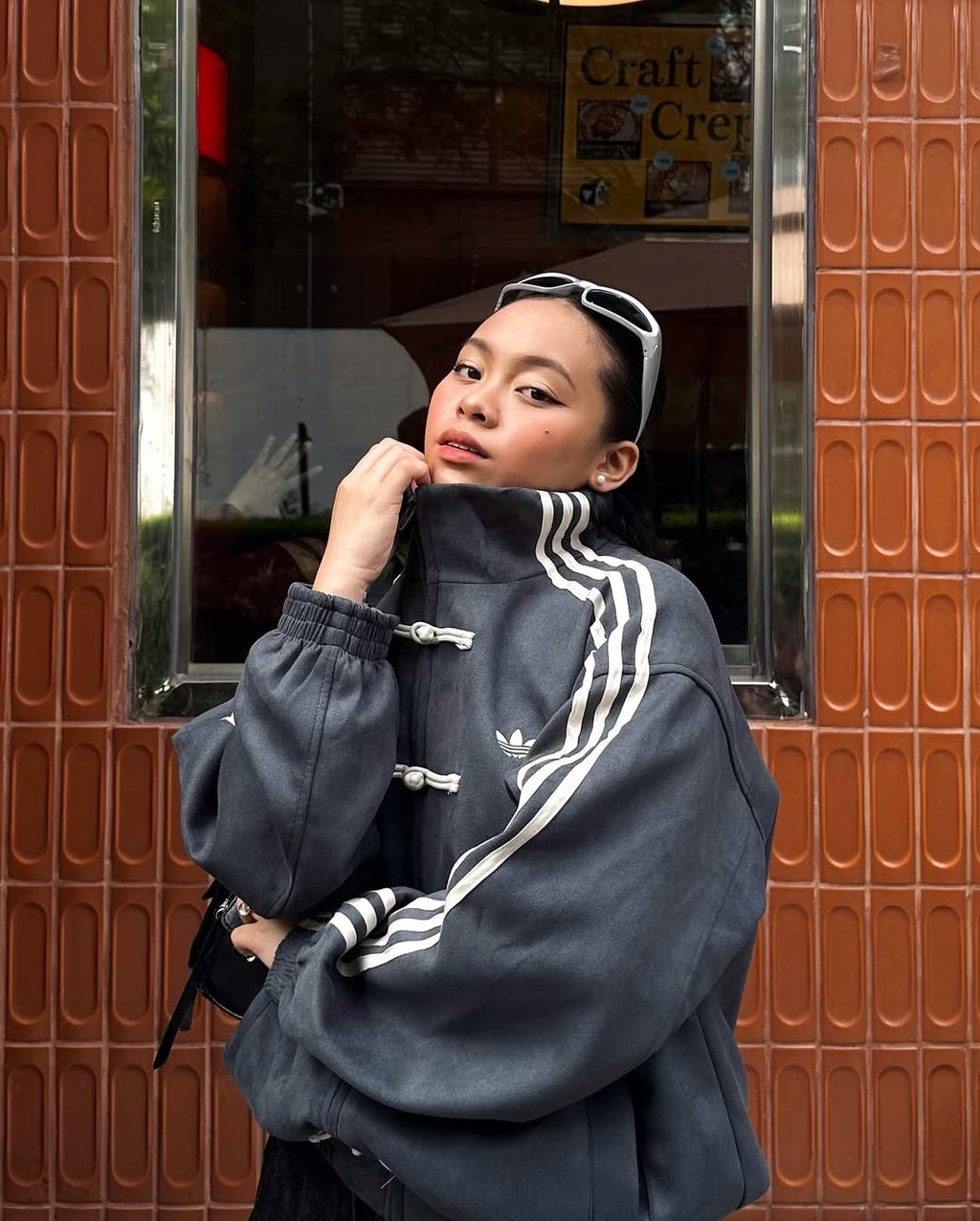 Frontal shot of the female model wearing the Dark Grey CNY Knot Jacket. Perfectly executes the highly sought-after "model off-duty" look by combining the ultra-oversized mens-cut suede bomber over tight streetwear base layers.
