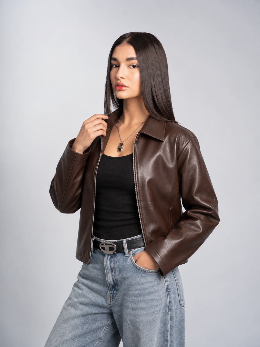 Female model styling the unisex Streetbred brown leather jacket, showing how the boxy cropped fit perfectly complements a Y2K aesthetic