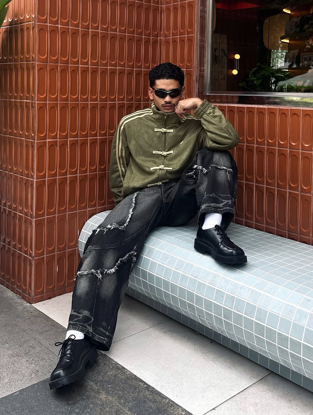 Back view shot of the male model showcasing the extreme width of the oversized dropped shoulders on the Olive Green bomber, proving it is precisely tailored for modern wide-fit clothing trends.